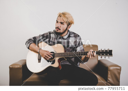 Close up of hipster beard man hand playing guitar. 77955711