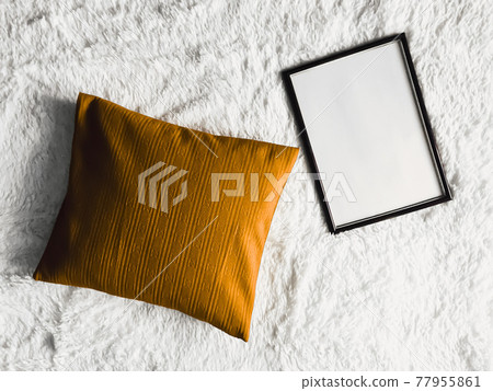 Black thin wooden frame with blank copyspace as poster photo print mockup, golden cushion pillow and fluffy white blanket, flat lay background and art product 77955861