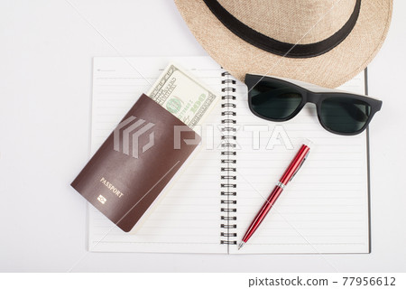 Passports,hat, camera ,glasses, pen on a paper floor ready to travel. Passports,hat, camera ,glasses, pen on a paper floor ready to travel. 77956612
