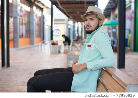 Handsome hipster young man with white headphones outside in the town. Chilling out. Handsome hipster young man with white headphones outside in the town. Chilling out. 77956929
