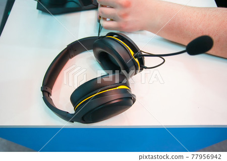 Black headphones for playing video games. 77956942