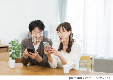 看智能手機的夫婦 77957434