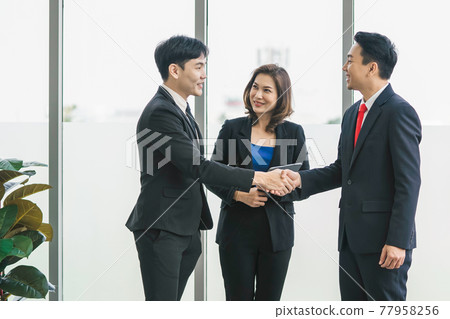 businessman standing shaking hand in office 77958256