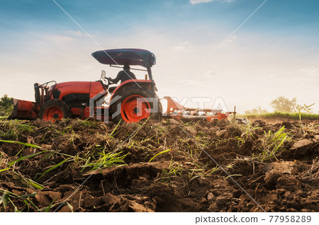 Farmer with tractor prepares the land to grow agricultural crops. Farmer with tractor prepares the land to grow agricultural crops. 77958289