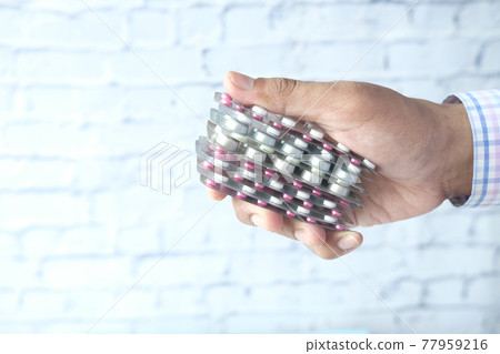 Close up of hand holding blister packs . Close up of hand holding blister packs . 77959216