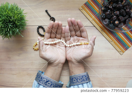 muslim man keep hand in praying gestures during ramadan, Close up muslim man keep hand in praying gestures during ramadan, Close up 77959223