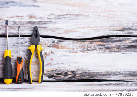 Screwdrivers and pliers on wooden background. Screwdrivers and pliers on wooden background. 77959225