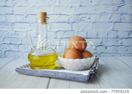 close up of eggs in a bowl and cooking oil in a glass jar close up of eggs in a bowl and cooking oil in a glass jar 77959229