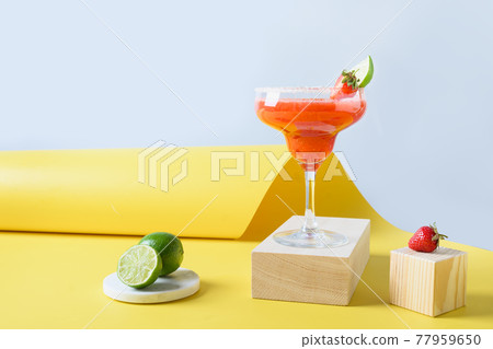 Classic Margarita cocktail with lime juice and ice cube on black background. Vertical orientation. Classic Margarita cocktail with lime juice and ice cube on black background. Vertical orientation. 77959650