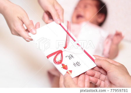 Handing a newborn baby gift from a senior to a mother 77959781