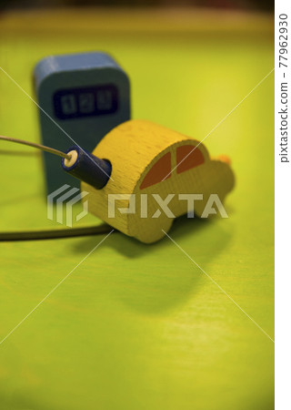 黃色汽車玩具正在加油(充電)。 黃色汽車玩具正在加油(充電)。 77962930