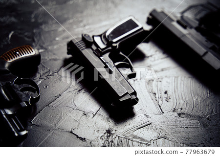 Three guns on black table. 77963679