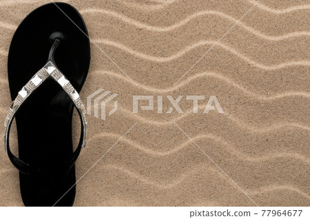 Sandy beach background with flip flops. Summer concept. Sandy beach background with flip flops. Summer concept. 77964677
