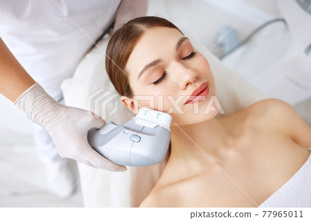 Woman getting facial lifting therapy in beauty salon Woman getting facial lifting therapy in beauty salon 77965011