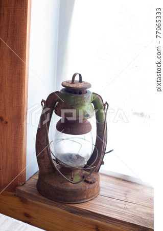 Old metal kerosene lamp on the window. Museum exhibit, close-up Old metal kerosene lamp on the window. Museum exhibit, close-up 77965333