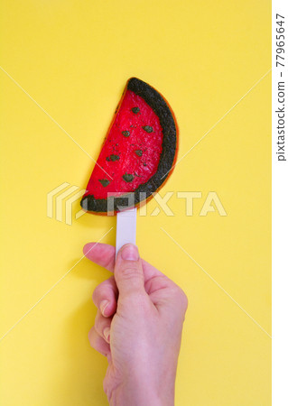 Hand holding watermelon popsicle 77965647
