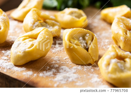 Uncooked pelmeni dumplings on rustic 77965708