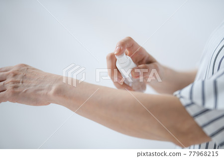 Senior woman sunscreen insect repellent at hand 77968215