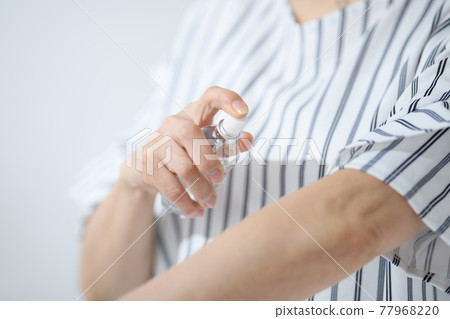 Senior woman sunscreen insect repellent at hand 77968220