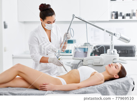 Woman having laser treatment in beauty clinic 77969510