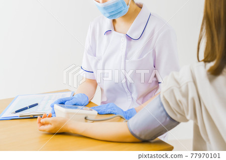 A nurse measuring a patient's blood pressure A nurse measuring a patient's blood pressure 77970101