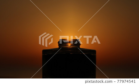 Glass bottle shining in the sunlight Glass bottle shining in the sunlight 77974541