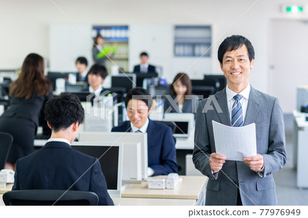 站立在辦公室的中年商人 77976949