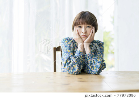 一個年輕女子,臉頰上一副愁眉苦臉的樣子 一個年輕女子,臉頰上一副愁眉苦臉的樣子 77978096