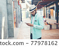 Hipster man listening music with his smartphone on the street in urban. 77978162