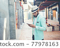 Hipster man listening music with his smartphone on the street in urban. 77978163