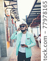 Hipster man listening music with his smartphone on the street in urban. 77978165