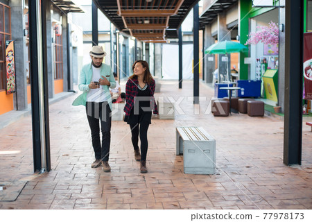 Young couple walking together on urban street. Couple in love concept. Young couple walking together on urban street. Couple in love concept. 77978173