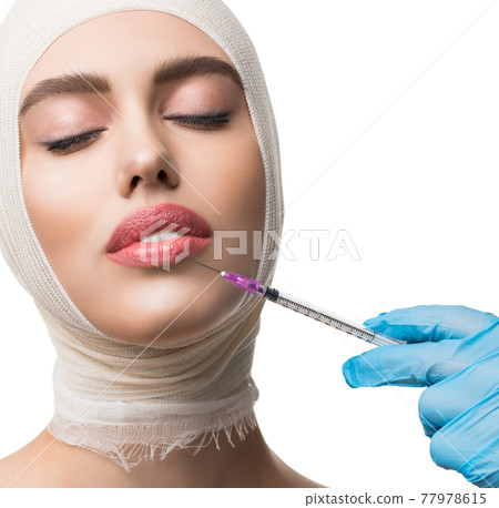 Woman her head bandaged getting lips injections Woman her head bandaged getting lips injections 77978615