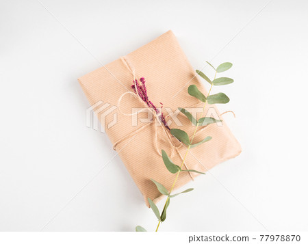 Wrapped gift boxes in craft paper with dried flowers decor 77978870