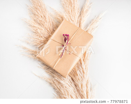 Gift box wrapped in craft paper with dried flowers Gift box wrapped in craft paper with dried flowers 77978871