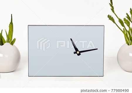Watch with black hands without a dial surrounded by vases with green plants or flowers, isolated on white. Close up, copy space. Empty blank mock up 77980490