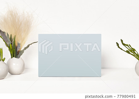 Empty blank mock up on tabletop surrounded by vases with green plants or flowers, isolated on white. Close up, copy space Empty blank mock up on tabletop surrounded by vases with green plants or flowers, isolated on white. Close up, copy space 77980491