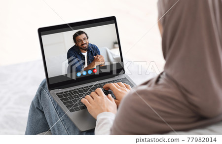 Online Communication. Woman In Hijab Having Video Call On Laptop With Husband Online Communication. Woman In Hijab Having Video Call On Laptop With Husband 77982014