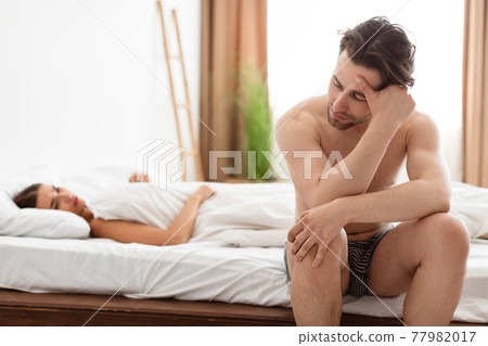 Unhappy Man Having Erection Problems While Girlfriend Lying In Bedroom 77982017