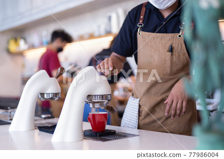 Flair espresso machine in a coffee shop with barista. 77986004
