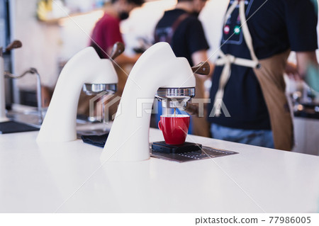 Flair espresso machine in a coffee shop with barista. 77986005