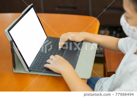 Young student with protective mask hands typing on laptop. Young student with protective mask hands typing on laptop. 77986494