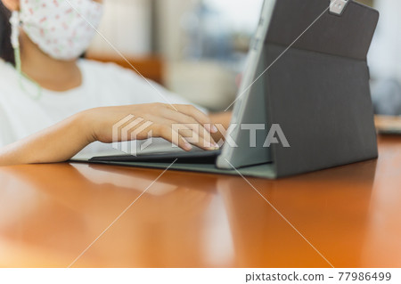 Young child student with protective mask hands typing on laptop. Young child student with protective mask hands typing on laptop. 77986499