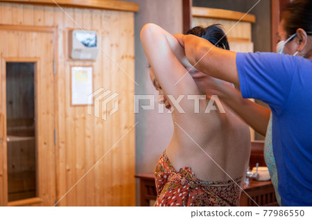 Woman having Thai massage at spa on vacation. 77986550
