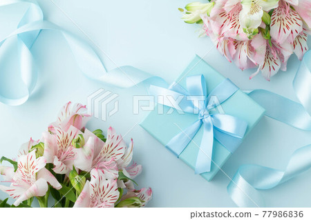 用淺藍色絲帶和粉紅色六出花禮物裝飾的盒子的圖像 用淺藍色絲帶和粉紅色六出花禮物裝飾的盒子的圖像 77986836