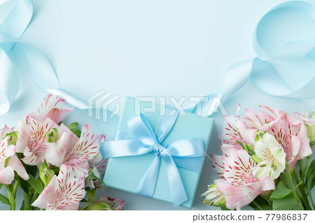 用淺藍色絲帶和粉紅色六出花禮物裝飾的盒子的圖像 用淺藍色絲帶和粉紅色六出花禮物裝飾的盒子的圖像 77986837