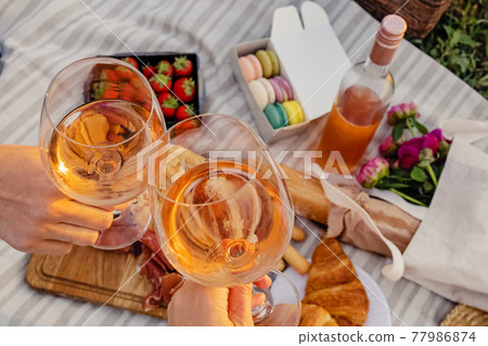 Couple clinking with two glasses of rose wine. 77986874