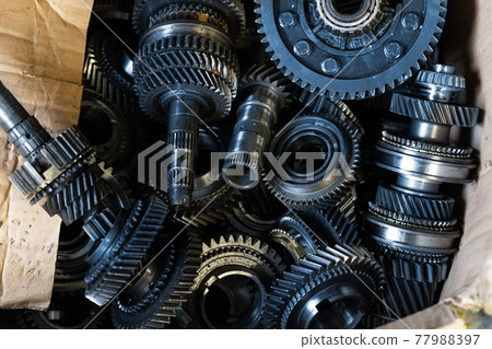 Closeup disassembled car automatic transmission gear part on workbench at garage or repair factory station for fix service or maintenance. Vehicle part detail. Complex industrial mechanism background 77988397