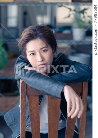 Genderless LGBT woman sitting in a chair and glaring 77988684