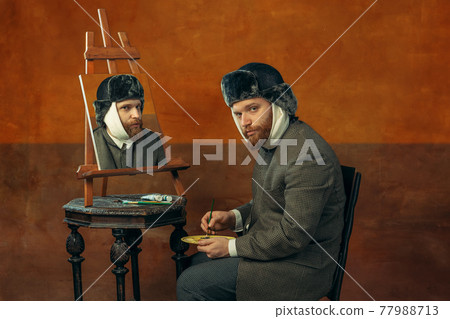Portrait of red headed and bearded man playing famous artist isolated over dark bacground Portrait of red headed and bearded man playing famous artist isolated over dark bacground 77988713